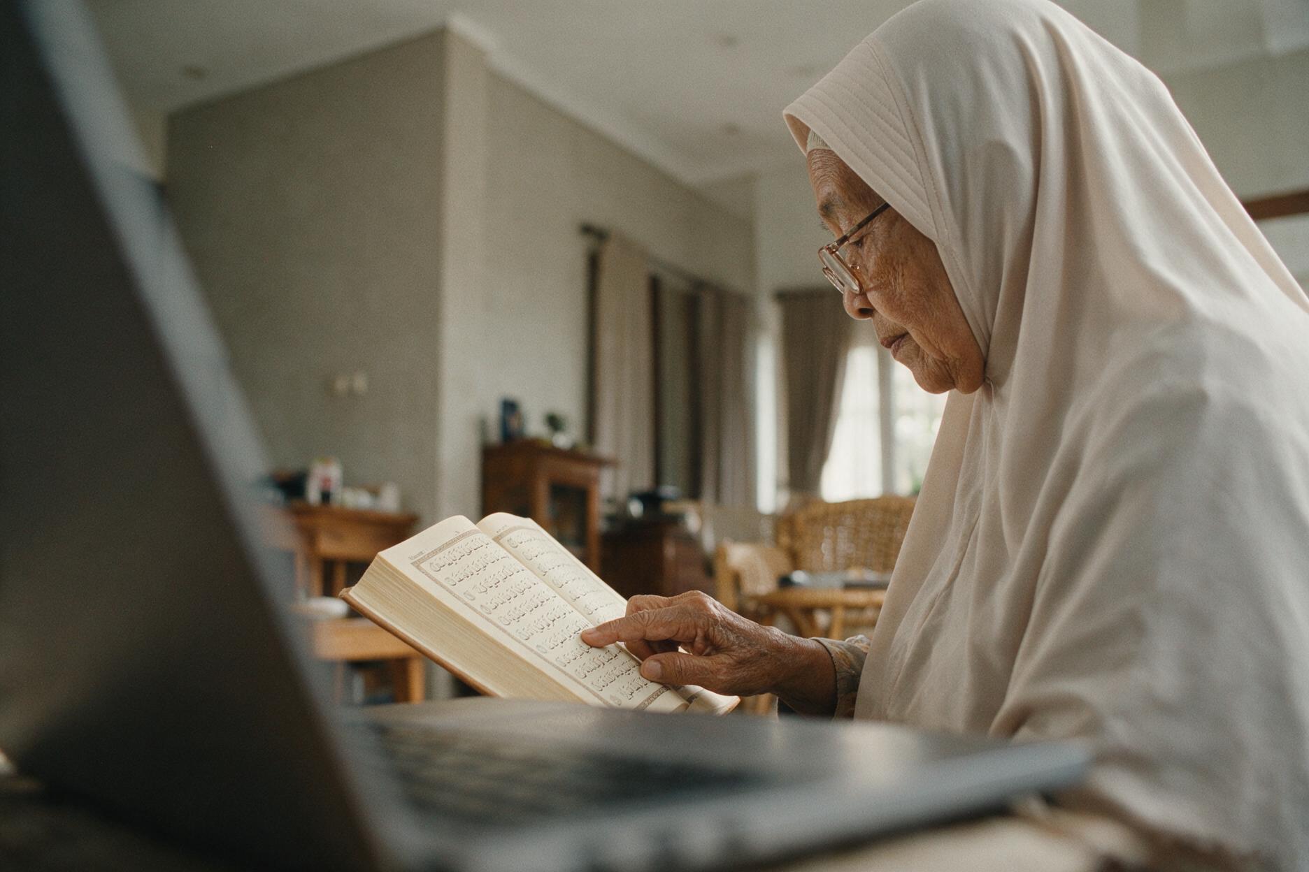 Seorang nenek menyusuri baris mushaf dengan jarinya.
